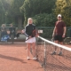 Vier Personen mit Tennisschläger gucken in die Kamera